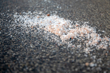 Salt spilled on the pavement. Winter season