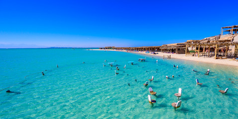 Orange Bay Beach with crystal clear azure water and white beach - paradise coastline of Giftun island, Mahmya, Hurghada, Red Sea, Egypt. - obrazy, fototapety, plakaty