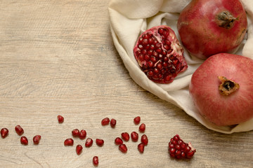 Ripe pomegranates in the white bag and seeds on the table. Macro background. Top view.