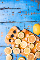Sliced Lemons and Limes with ice cube. Over blue wood table background with copy space ,spring time concept
