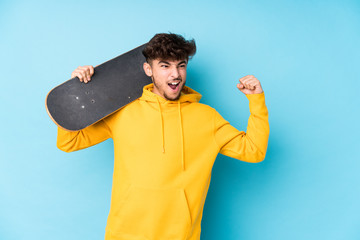 Young arab skater man isolated raising fist after a victory, winner concept. © Asier