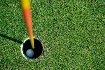 Golf ball is beside the hole