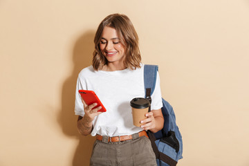 Image of caucasian student girl holding takeaway coffee cup and smartphone