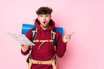 Young arab traveler man holding a map pointing to the side
