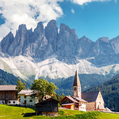 Impressively beautiful view on Famouse church and with the Odle or Geisler Dolomites mountains in the Val di Funes Valley in South Tyrol in Italy. The small village of St. Magdalena or Santa Maddalena