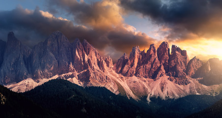 Awesome landscape with colorful sky over the Odle group or Geisler Dolomites mountains. Wonderful picturesque Scene. Fantastic View on Majestic Rocky Mountains Peaks with Dramatic sky during sunset