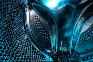 Futuristic look of a washing machine drum made of steel in blue light