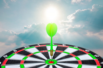 Planning new business target and goals, Green dart arrow hitting in the target center of dartboard...