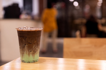 iced mint chocolate drink in plastic glass, put on a wooden table