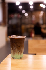 iced mint chocolate drink in plastic glass, put on a wooden table