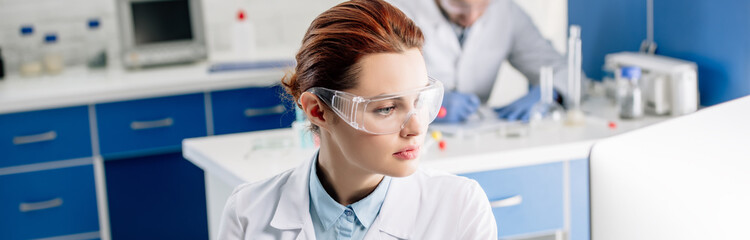 panoramic shot of genetic consultant using computer in lab