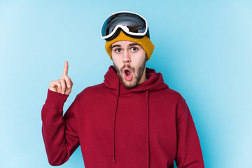 Young caucasian man wearing a ski clothes isolated having some great idea, concept of creativity.