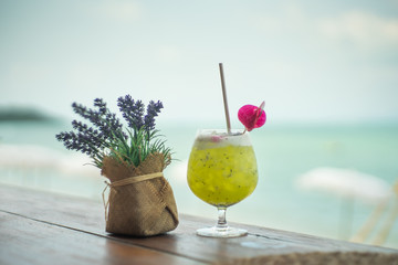 Dragon fruit juice beverage over water hyacinth tray on terrace wood with beach and sea summer background