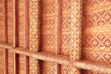 Golden pattern drawn on wooden boards of the roof of an old house.