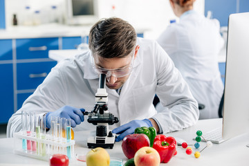 molecular nutritionist in white coat using microscope in lab