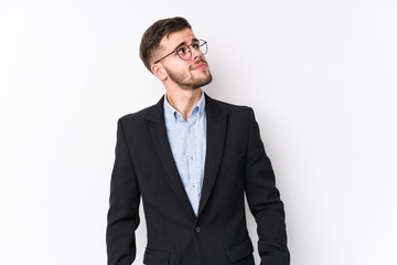 Young caucasian business man posing in a white background isolated Young caucasian business man dreaming of achieving goals and purposes