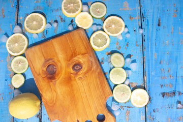 Sliced Lemons and Limes with ice cube. Over blue wood table background with copy space ,spring time concept