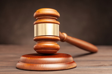 Wooden hammer of the judge. Brown background
