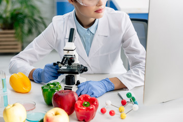 cropped view of molecular nutritionist looking at computer in lab