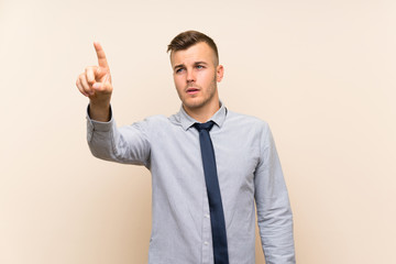 Young blonde businessman over isolated background touching on transparent screen