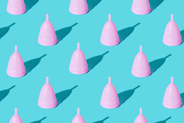 Pink menstrual cup on a green background. Set. Texture - obrazy, fototapety, plakaty
