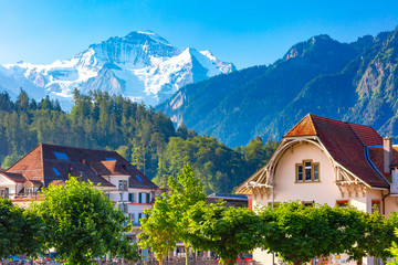 Houses in Old City of Interlaken, important tourist center in the Bernese Highlands, Switzerland. The Jungfrau is visible in the background - obrazy, fototapety, plakaty