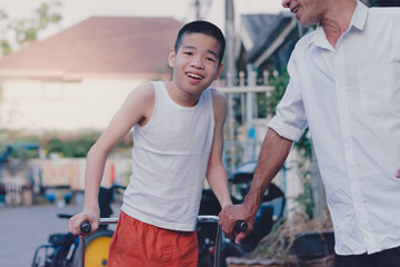 Fototapeta na wymiar Disabled child is doing physical with father in the evening, He is ready to practice, Special children's lifestyle, Life in the education age of special need children, Happy disability kid concept.