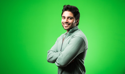 Portrait of Indian Young Man, standing isolated over green chroma key background