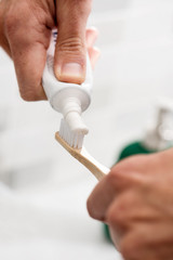man using a bamboo toothbrush in the bathroom