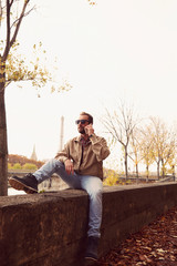 Handsome man using cellphone while enjoying in Paris.