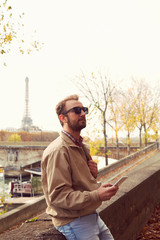 Handsome man using cellphone while enjoying in Paris.