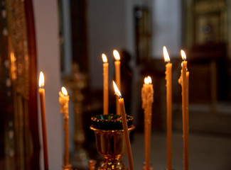 Burning in the dim light of candles in the Church.