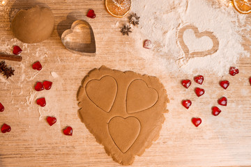 Valentine's day baking concept with heart shaped cutters and eggs on a dark wooden table with copyspace
