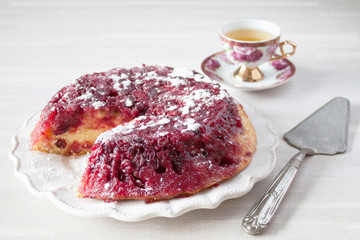 Cut round cranberry tart pie cake, white plate, wooden table, christmas new year decoration