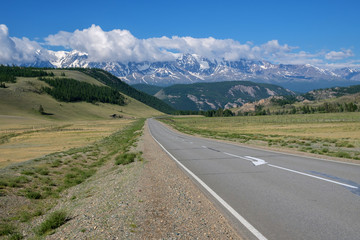 Fototapeta na wymiar Free road in the Altai mountains, snow-capped peaks, sunny day.