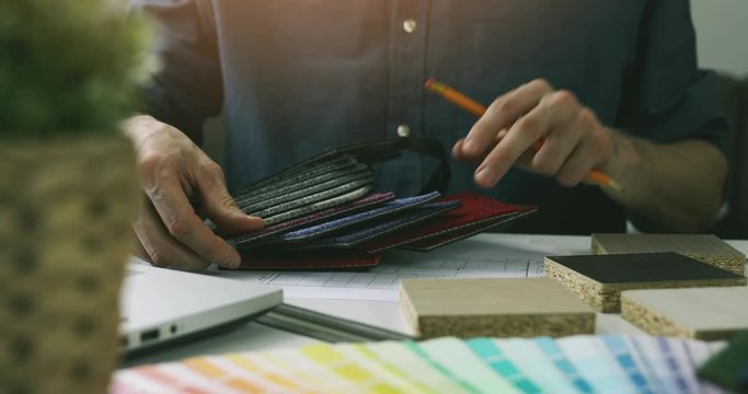 designer choosing flooring material and paint color from swatch for home interior design project