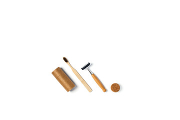Zero waste concept. Natural bamboo toothbrush, bamboo razor, paper tube, on isolated white background. Flat lay, top view, copy space.