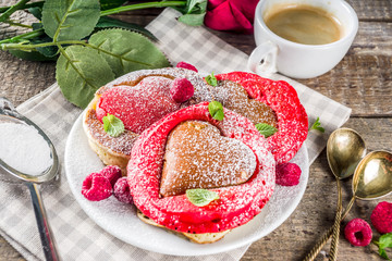 Valentine day brunch food recipe idea. Delicious homemade heart shaped red and white pancakes with berries. Concept of a festive breakfast for Valentine's Day, pleasant surprise for loved one