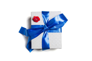 Grey gift box with a classic blue bow. The red rose is on it. Isolated on a white background with a shadow.
