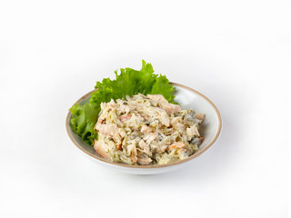 Salad with ham, bell pepper, mushrooms, pickles, seasoned with mayonnaise, on a white plate