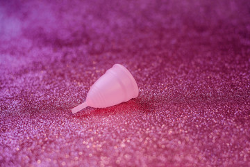 Pink menstrual Cup on a shiny pink background. Protection of women in holidays concept. World women's day. Valentine's day. February 14. Valentine day. Medicine. Gift.