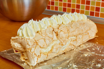 ready delicious sweet roll is on the table on foil on the background of a colored mosaic and a metal bowl