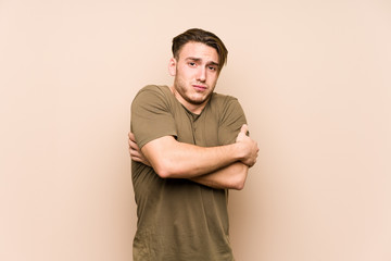 Young caucasian man posing isolated going cold due to low temperature or a sickness.