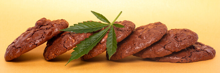 oatmeal cookies and green leaf of cannabis on a yellow background. marijuana cookies.