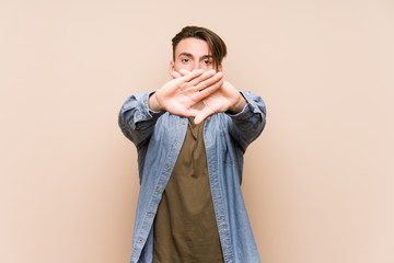 Young caucasian man posing isolated doing a denial gesture