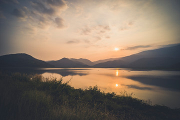 Fototapeta premium Mountain, sky and river in a quiet and cool atmosphere. Similar color scheme .View of blue mountains with reflection in lake . Landscape with blue mountains near lake in Sukhothai Thailand