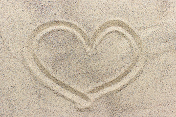 Fototapeta na wymiar Heart shape drawn on sand surface
