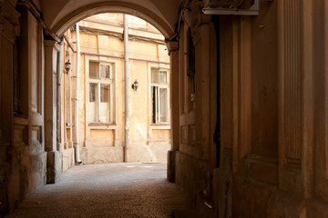 Passage through the arch to typical courtyard of the old historic building in Odessa city center, Ukraine