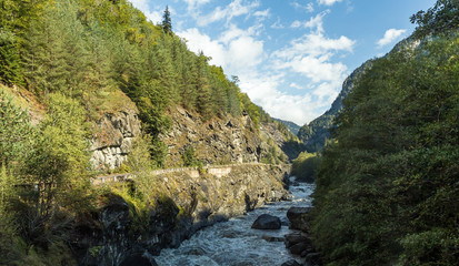 Stormy  mountain river Patara Enguri flowing at the foot of the mountains in Svaneti in the mountainous part of Georgia in the early morning