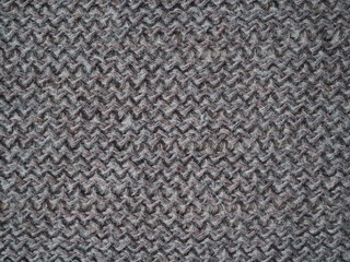 Knitted fabric texture. Gray. Simple knitting with front and back loops. Knitting on the knitting needles. Horizontal lines.